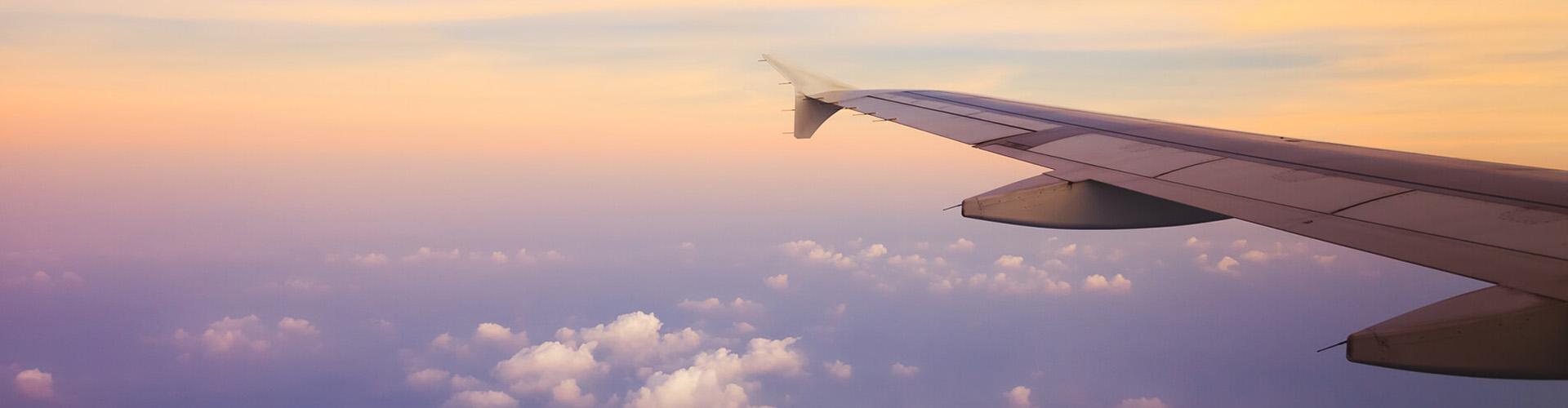 Momento comenzar a exportar e importar - Ala de un avión rodeado de nubes